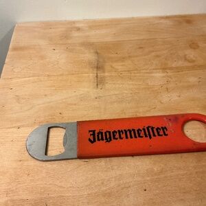 Vintage Jägermeister orange rubber-coated metal bar bottle opener.